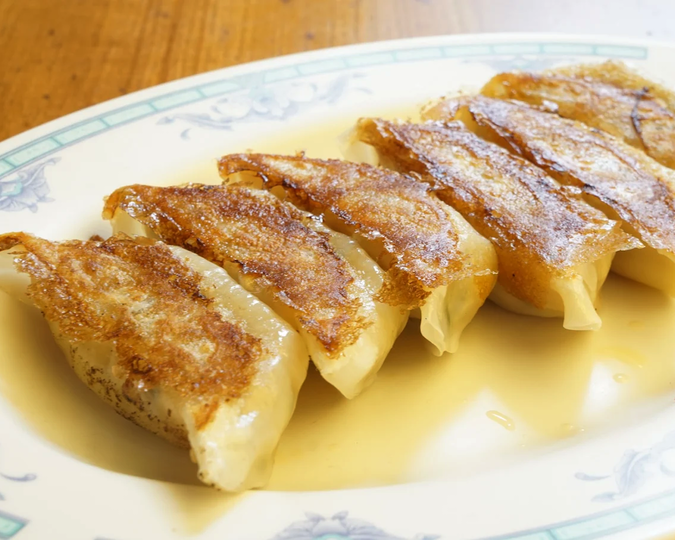 Cuppage Plaza Food : A plate of crispy golden gyoza served with dipping sauce at a cosy Japanese-Chinese eatery.