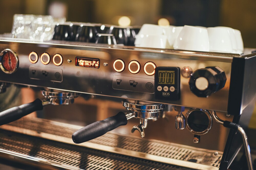 Best Cafe in SG : Sleek coffee maker machine on a wooden counter in a cozy cafe