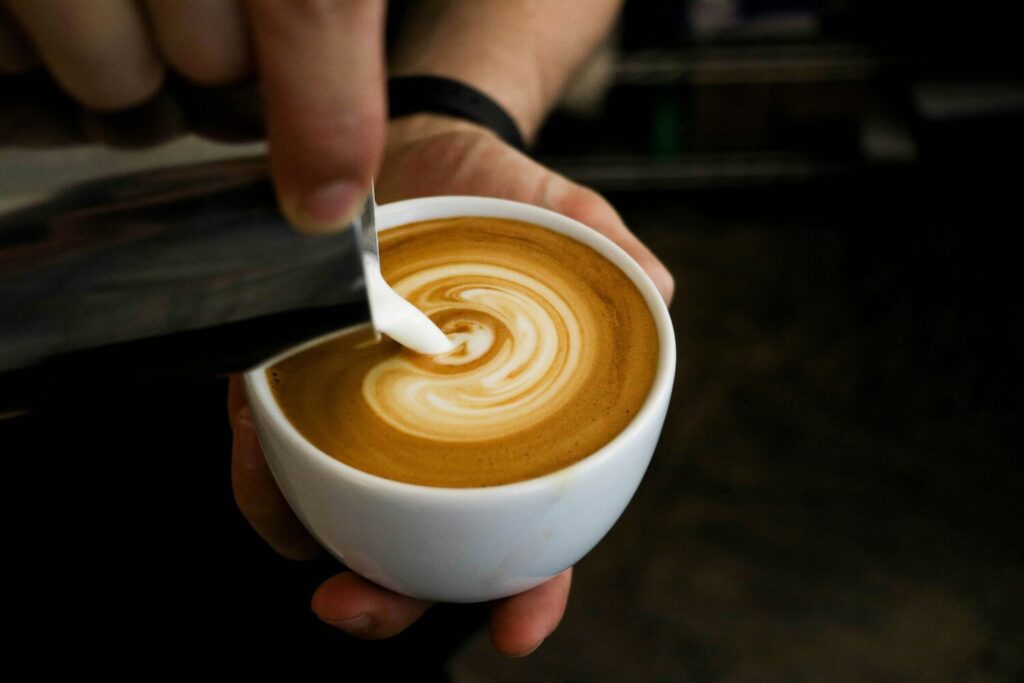 Best Cafe in SG : Skilled barista pouring rosetta pattern into a flat white