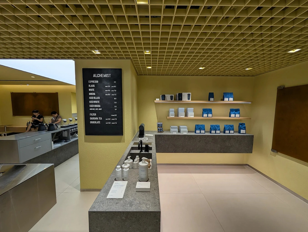 Best Coffee in SG : The Heeren flagship Alchemist outlet with its minimalist white interiors and open bar counter, reflecting the brand’s focus on design and accessible excellence in specialty coffee.