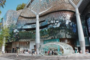 Beyond the Orchard Road : Window displays showcasing high-end fashion brands inside a polished retail corridor.