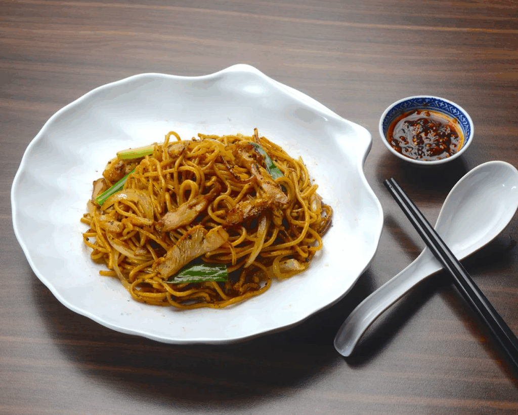 Beyond the Orchard Road : Savoury ramen with sambal on a rustic wooden table.