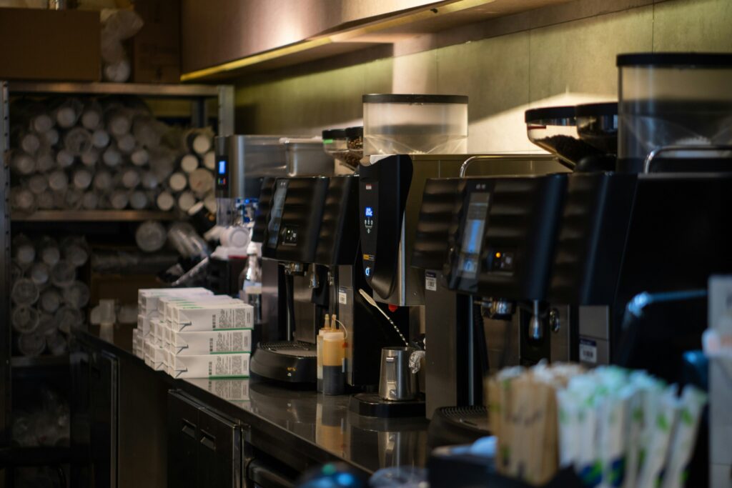 Best Coffee in SG : Close-up of a high-end coffee machine steaming milk, showcasing the craftsmanship behind every silky flat white served in Singapore’s best cafés.
