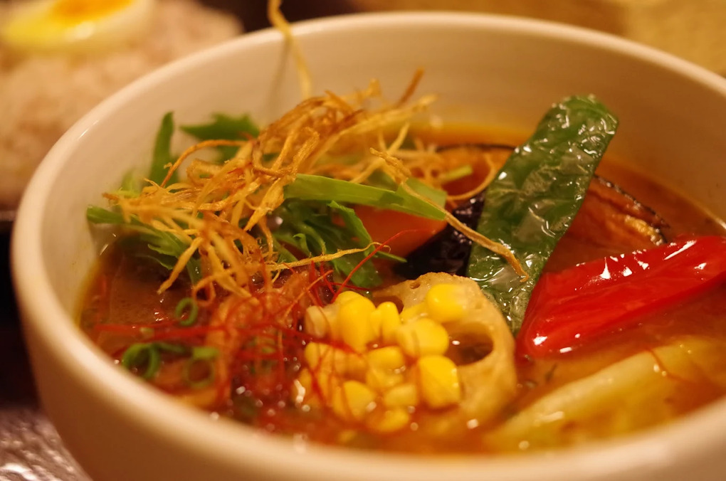 Sapporo Soup Curry in SG : A close-up of aromatic soup curry with glistening broth and soft, tender meat, showcasing the perfect harmony between spice, warmth, and simplicity.