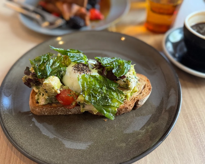 A plate from Chye Seng Huat Hardware featuring toasted bread topped with eggs, styled neatly on a café table to highlight their brunch menu.