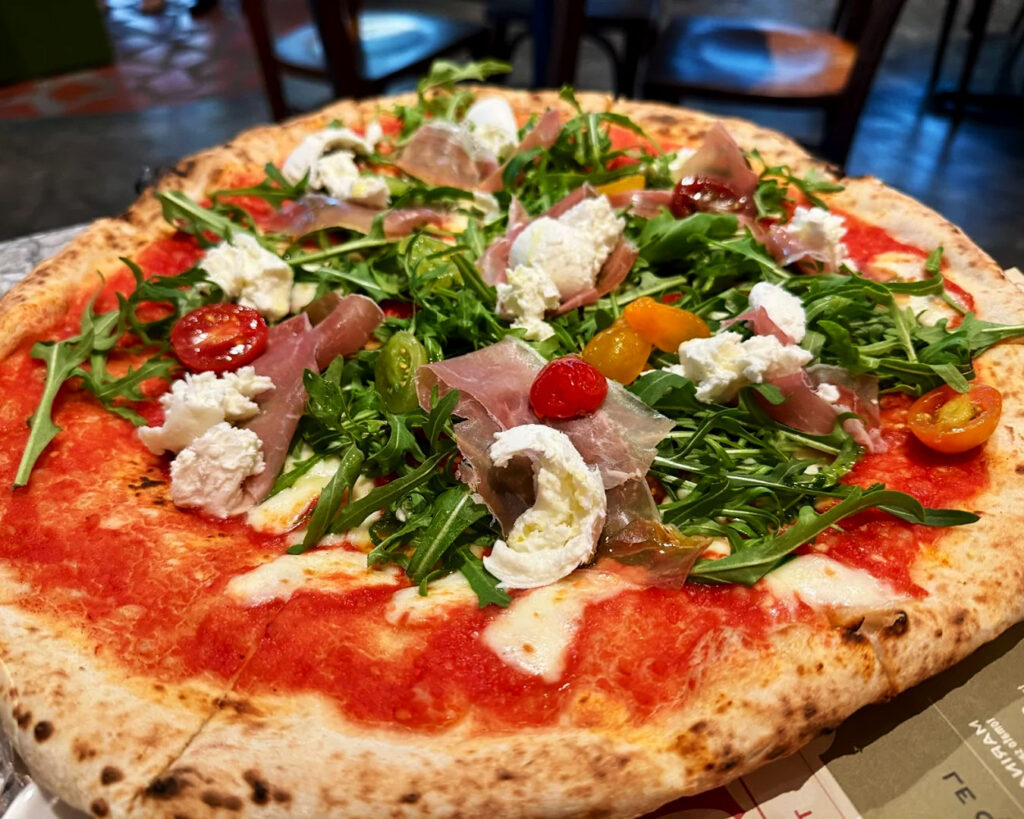 Authentic Neapolitan pizza with a perfectly charred thin crust, fresh tomato sauce, and creamy mozzarella, served piping hot at L’Antica Pizzeria da Michele