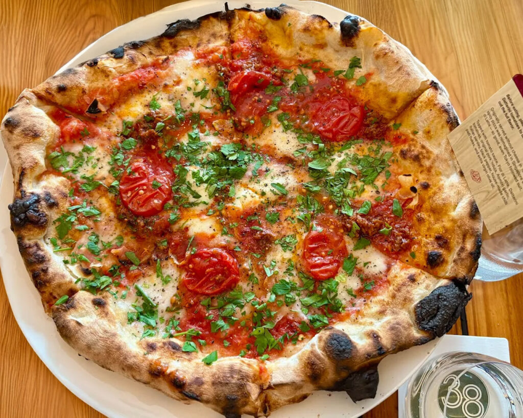 Artisan pizza with a creative twist, featuring a hand-stretched crust, gourmet toppings, and a visually striking presentation at Pizza Studio Tamaki