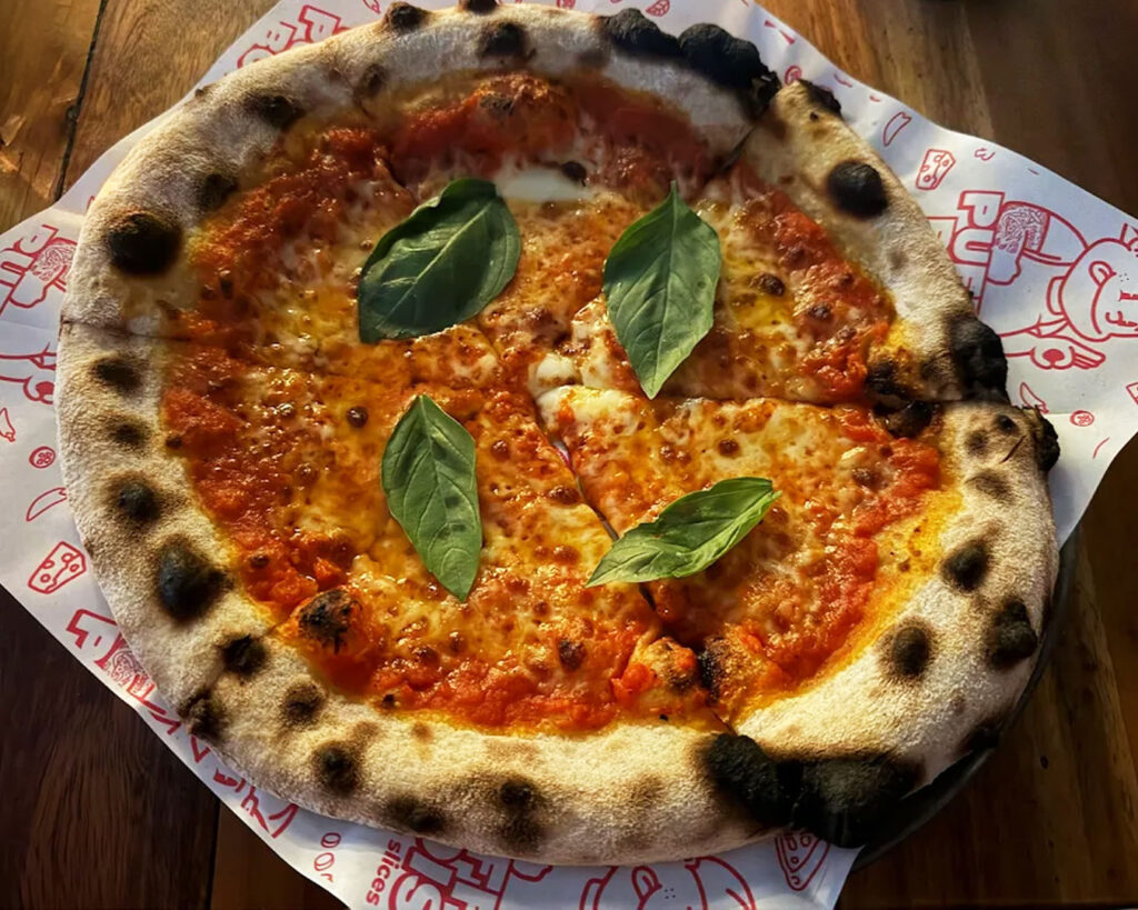 Fluffy, airy-crust pizza with vibrant toppings and melted cheese, showcasing Puffy Bois’ signature light and soft base