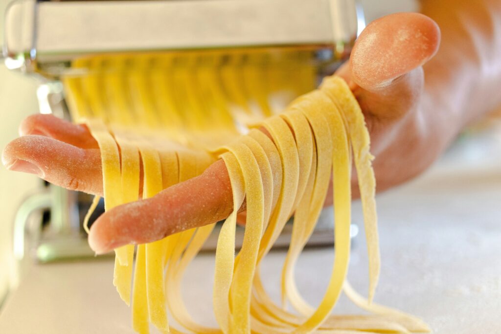 Close-up of a chef carefully preparing handmade pasta from scratch, demonstrating the skill and dedication of artisans who specialise in traditional Italian pasta-making techniques.