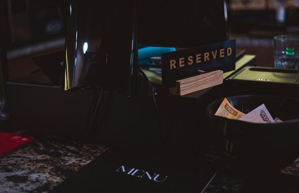 A close-up of a stylish “Reserved” sign placed on a table in a refined Italian restaurant, signalling an exclusive dining experience for guests