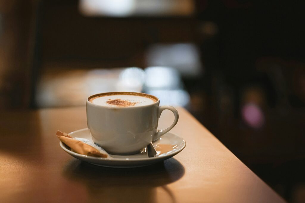 A neatly presented cup of coffee placed on a café table, surrounded by soft natural light that enhances its rich tones.