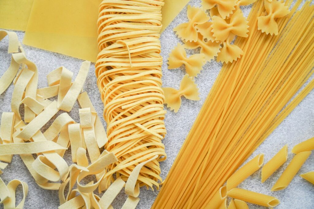 An assortment of different pasta types and shapes displayed together, highlighting the variety of textures and styles in Italian cuisine."