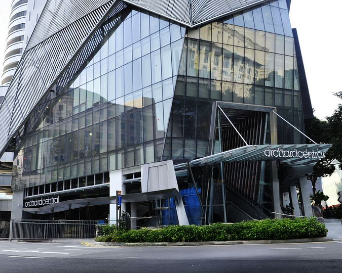 Orchard Central’s modern exterior featuring tall glass panels, vertical greenery, and a sleek urban façade along Orchard Road, Singapore.