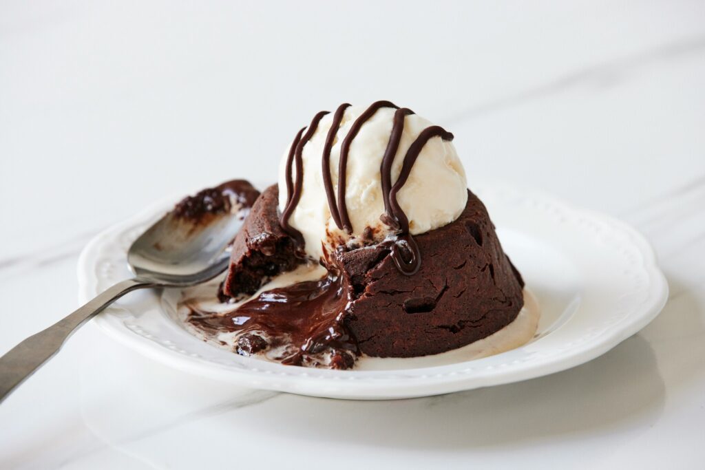 A decadent molten lava cake with a crisp exterior and flowing chocolate centre, served warm for the ultimate indulgence.