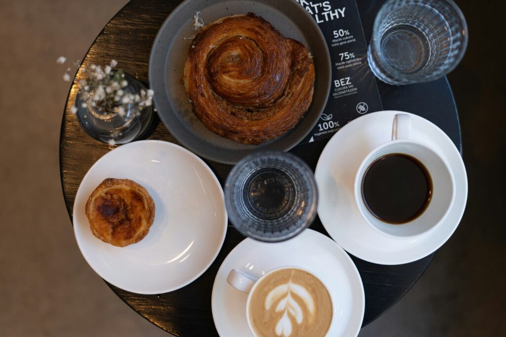 A freshly baked pastry served beside a warm cup of coffee, creating a cosy morning ambience perfect for a simple yet indulgent treat.