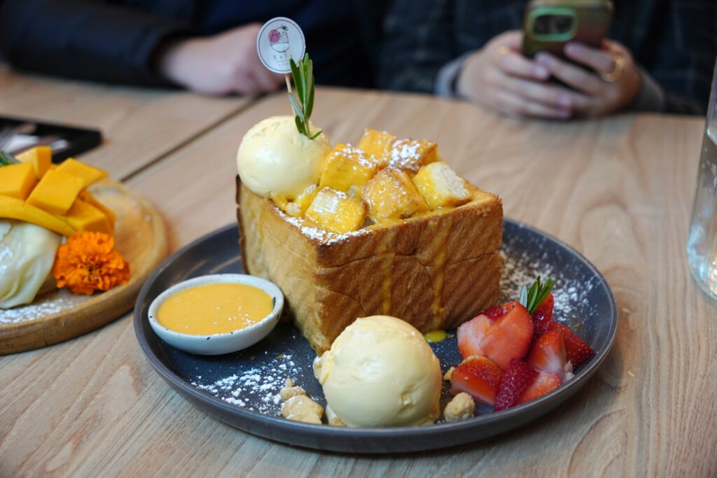 A warm, golden bread dessert topped with a scoop of melting vanilla ice cream, creating a perfect balance of texture and sweetness