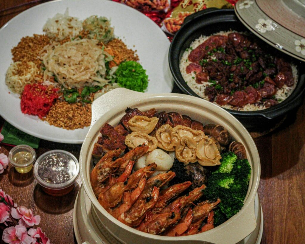 A lavish spread of Pen Cai and assorted Chinese New Year dishes arranged on a dining table, symbolising abundance, unity, and festive indulgence.