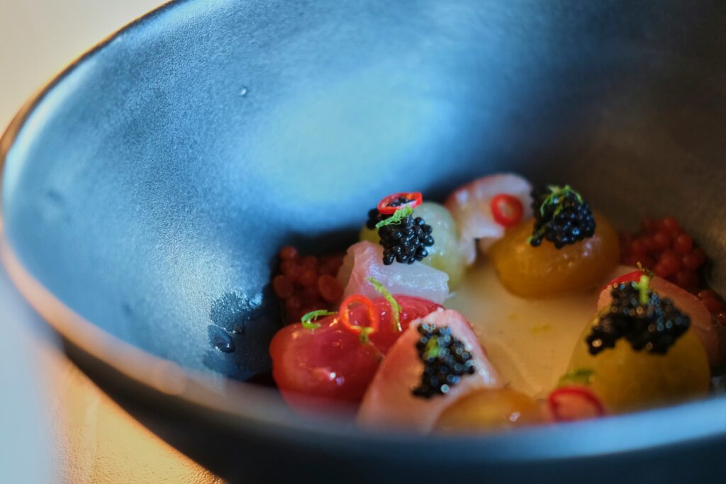 A refined Japanese dish topped with luxurious ingredients such as caviar, blending traditional Kaiseki techniques with modern gourmet elements.