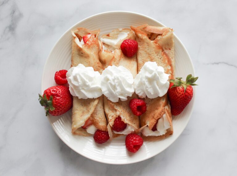 A delicate dessert crepe served at Orchard Central, folded with fresh fruits and cream, presented on a minimalist plate in a cosy café setting.