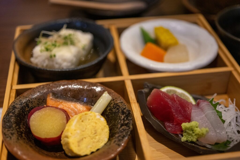 An artfully crafted kaiseki dish showcasing delicate flavours and meticulous Japanese culinary artistry on a minimalist wood plate.