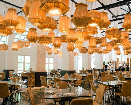 A warm and elegant interior of Candlenut restaurant, featuring modern Peranakan design elements, soft ambient lighting, and a refined dining atmosphere that reflects contemporary heritage.