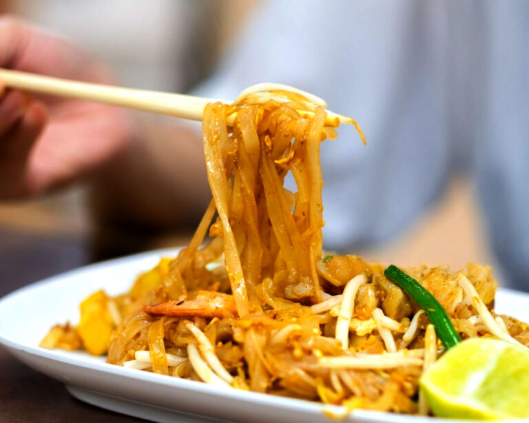A close-up of char kway teow showcasing simple yet rich ingredients—flat rice noodles, egg, prawns, and bean sprouts—highlighting the dish’s honest flavours and traditional preparation.