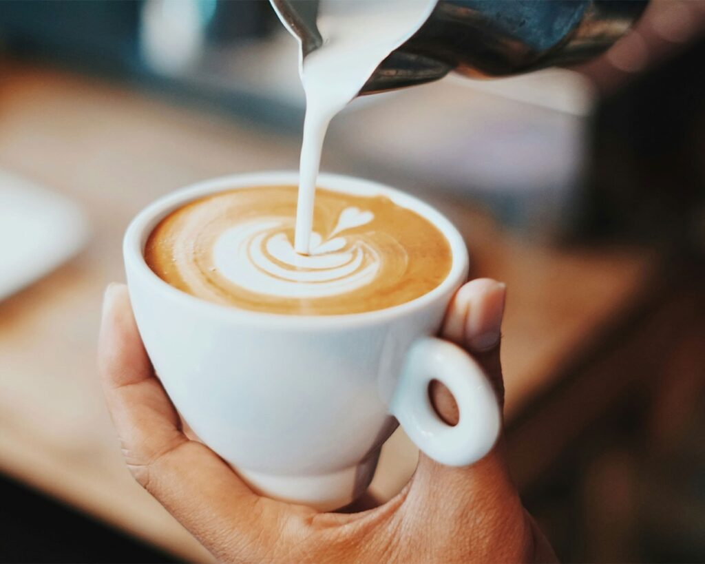 Barista carefully preparing coffee using professional equipment, focusing on craftsmanship and brewing technique.