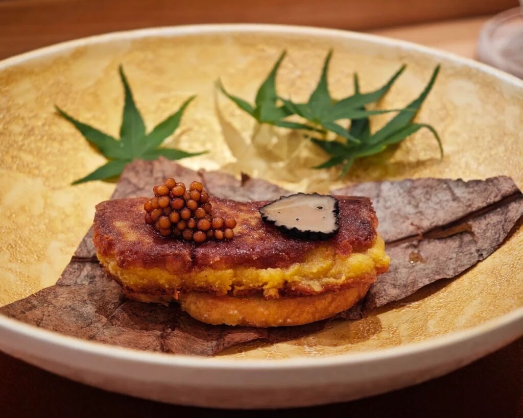 Silky truffle pâté topped with glossy tonburi “caviar,” offering a luxurious contrast of earthy aroma and subtle crunch in a refined presentation.