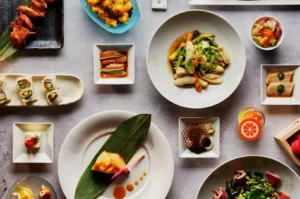 A variety of colorful Asian dishes on a table, including sushi, salads, and grilled meats, arranged artfully to create a vibrant and appetizing display.