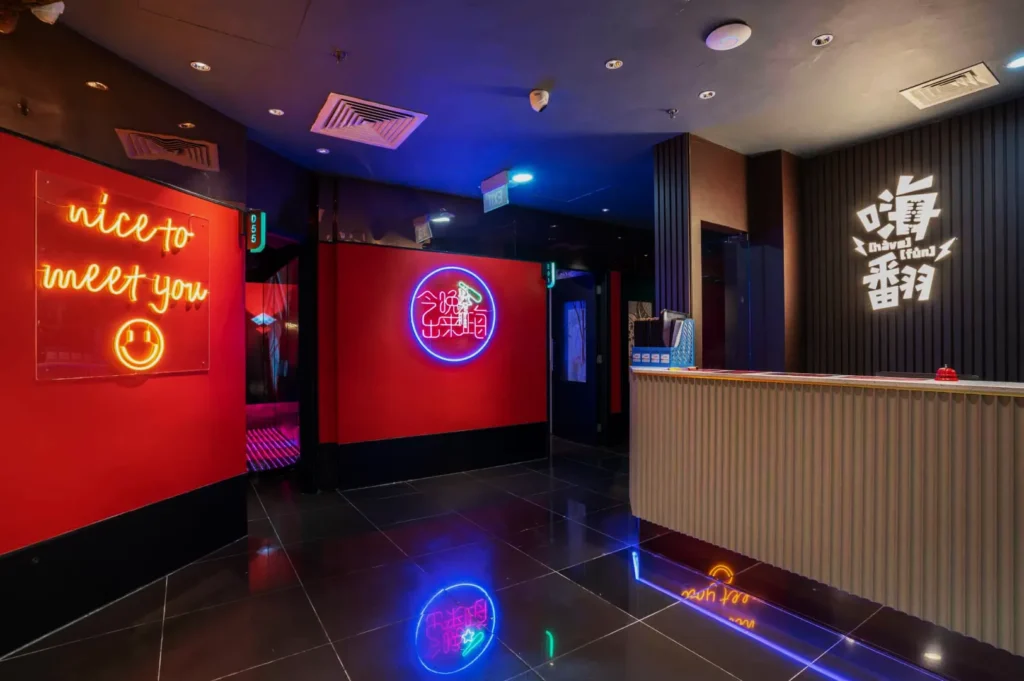 Trendy restaurant entrance with vibrant red walls, neon signs saying "nice to meet you" and another in Chinese characters, reflecting a lively atmosphere.