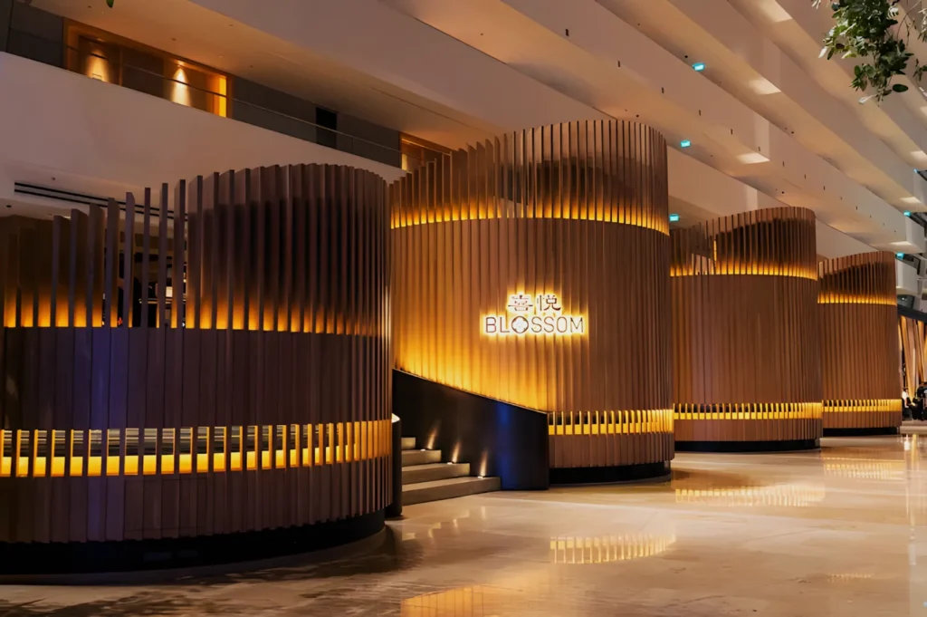 Stylish interior of Blossom restaurant with curved wooden partitions and warm lighting. The elegant, modern design conveys a welcoming atmosphere.