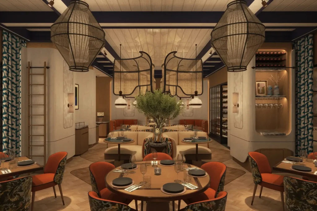 Cozy restaurant interior with warm lighting, round tables, and orange chairs. Large wicker lamps hang above, adding rustic charm. Relaxed ambiance.